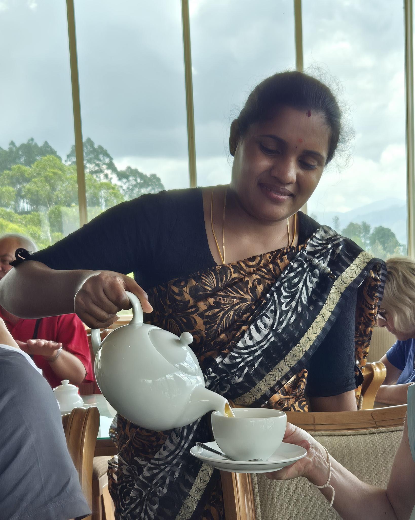 Frau serviert Tee in der Rothschild Tea Lounge